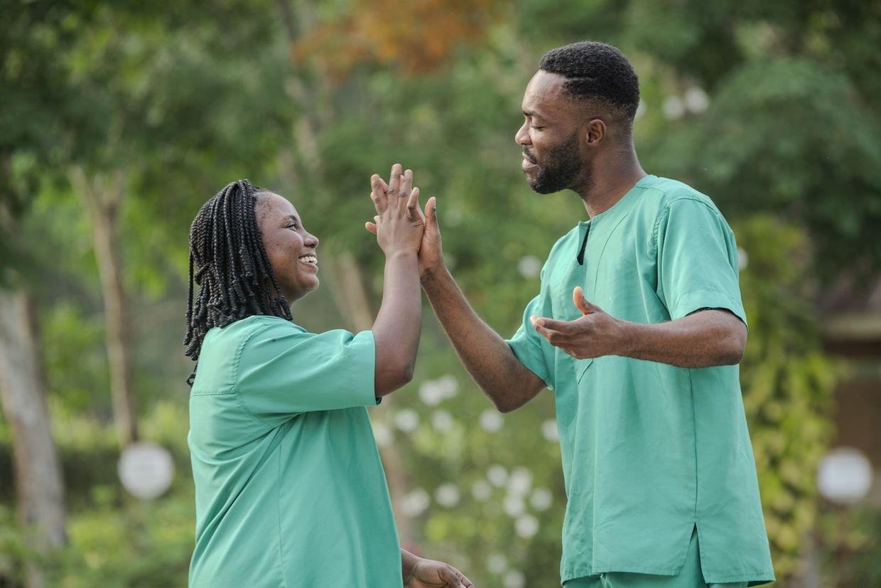 Two Ghanaian workers give each other a high five