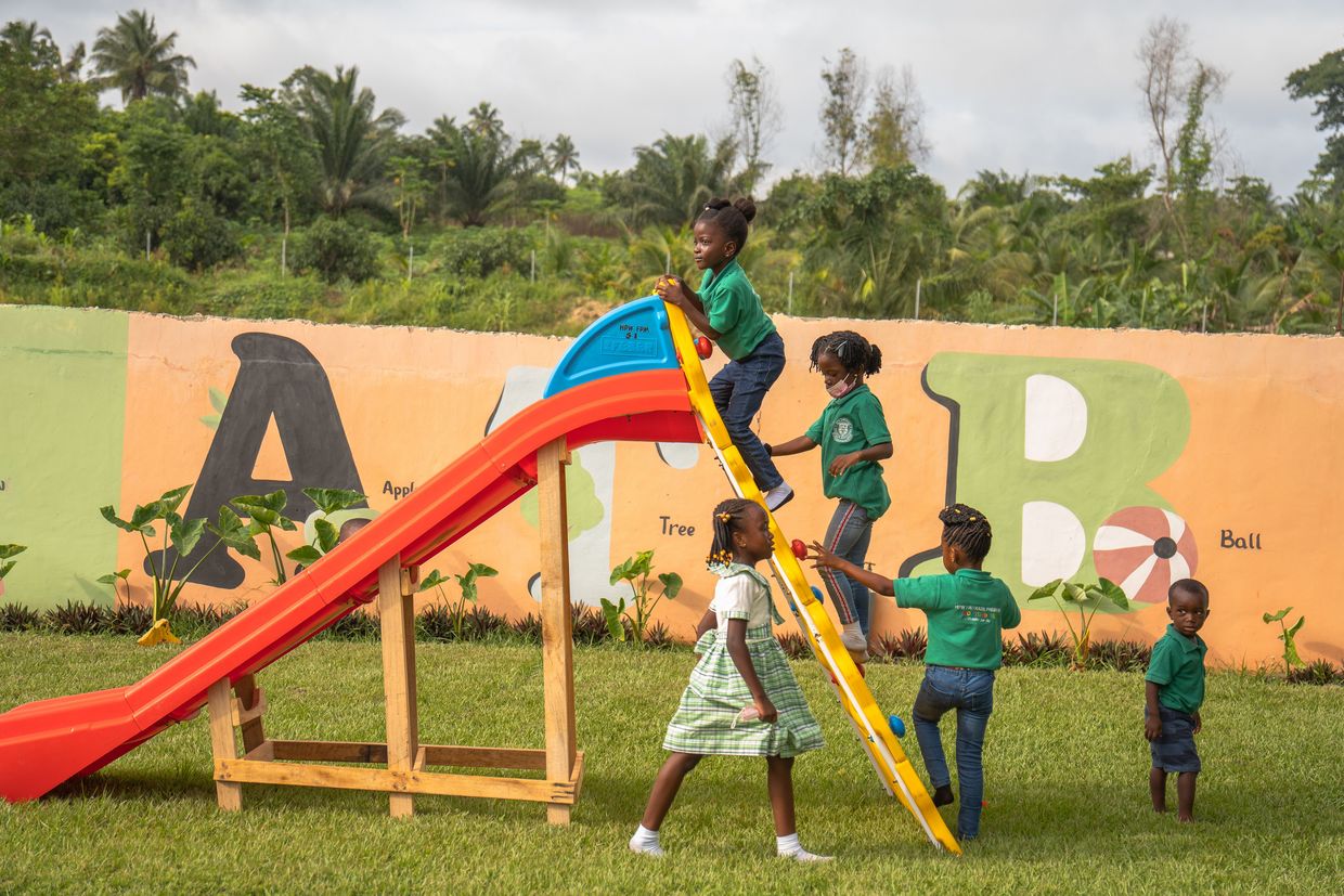 Children climb up a slide.