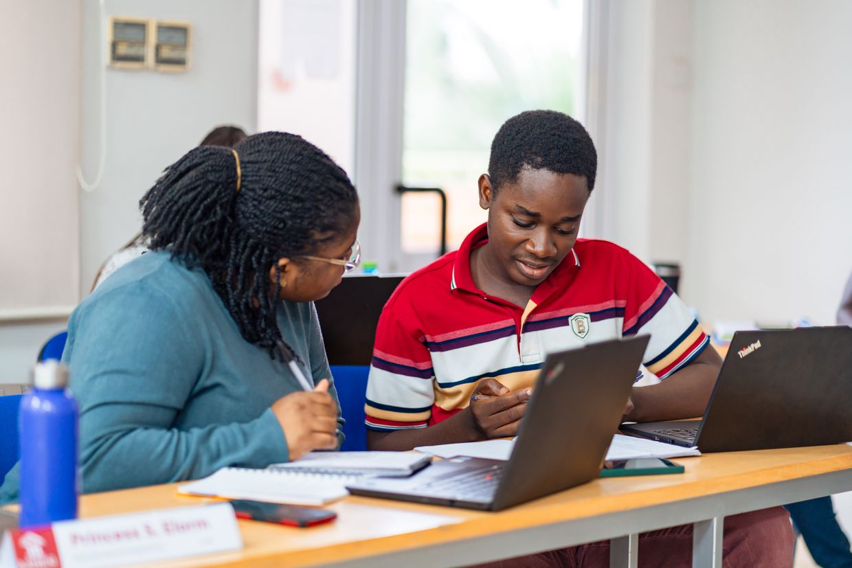 Two students sit at a table during a meeting.