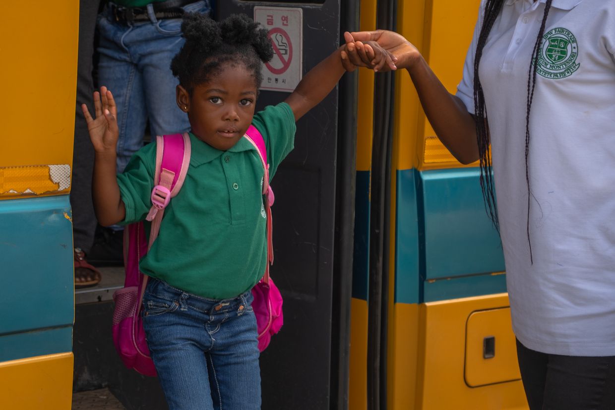 Une fille descend du bus scolaire et se rend à la crèche