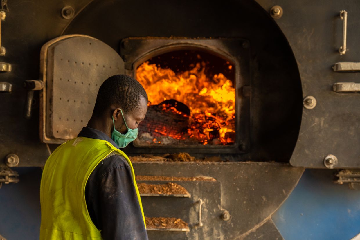 Worker standing in front of an open kiln